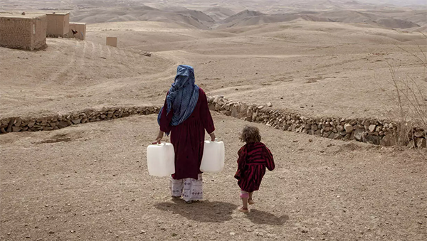 Afghanistan - Mutter mit Wasserkanister und Kind. 