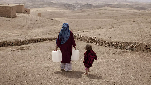 Afghanistan - Mutter mit Wasserkanister und Kind.